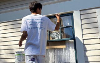 The Hidden Costs of Ignoring Exterior Paint Maintenance - Painter painting window trim with a brush