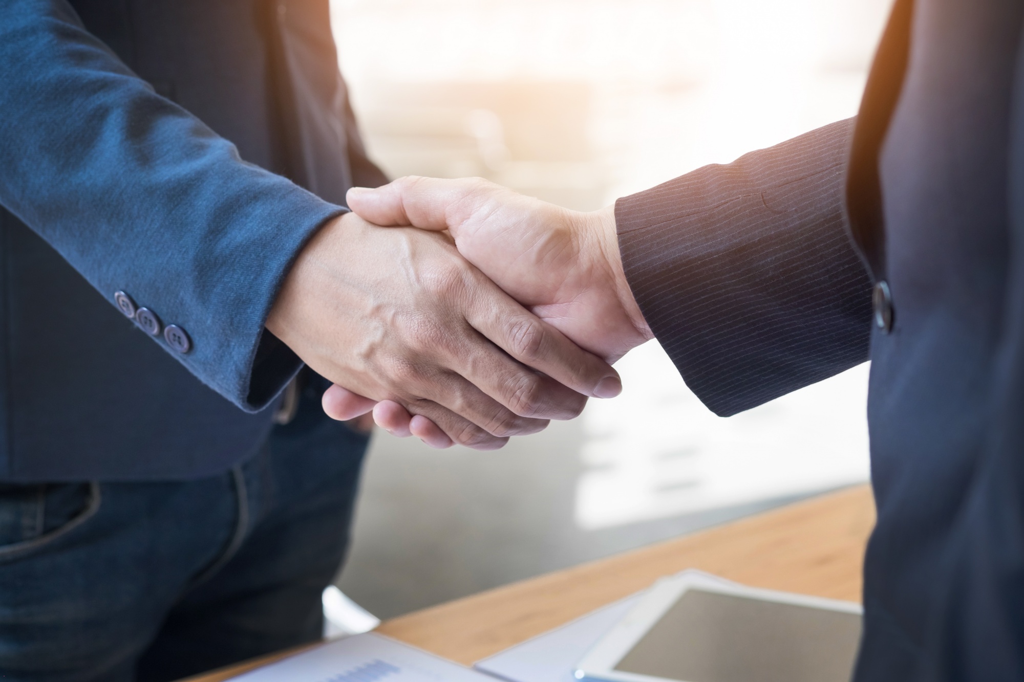 dos-hombres-de-negocios-confia-en-estrechar-la-mano-durante-una-reunion-en-la-oficina-el-exito-el-trato-el-saludo-y-el-concepto-de-socio