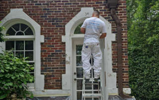 Behind the Scenes: What Makes Atlanta’s Paint Doctor Different - Atlanta's Paint Doctor's crew member standing on a ladder, working on an exterior project.