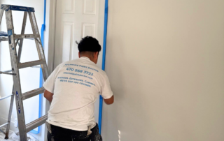 Why Touch-Ups Aren’t Always Enough - Atlanta's Paint Doctor's Crew Member Painting a wall of an interior project