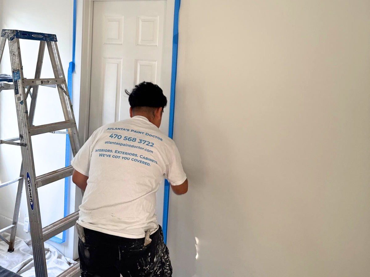 Why Touch-Ups Aren’t Always Enough - Atlanta's Paint Doctor's Crew Member Painting a wall of an interior project