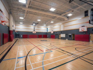 Más allá de las aulas: Gimnasios de pintura, pasillos y instalaciones deportivas en las escuelas de Atlanta - gimnasio escolar con acentos grises y rojos