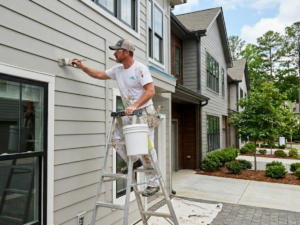 How to Select an Approved Painting Contractor for Your Atlanta Townhome Community - professional painter painting the siding of a Townhome in North Atlanta