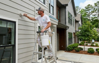 How to Select an Approved Painting Contractor for Your Atlanta Townhome Community - professional painter painting the siding of a Townhome in North Atlanta