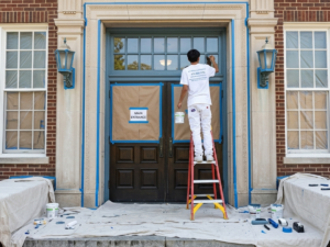What to Look for in a School Painting Contractor (A Guide for Metro Atlanta Schools) - Atlanta's Paint Doctor's team member painting the entrance of a school