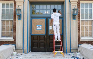 What to Look for in a School Painting Contractor (A Guide for Metro Atlanta Schools) - Atlanta's Paint Doctor's team member painting the entrance of a school