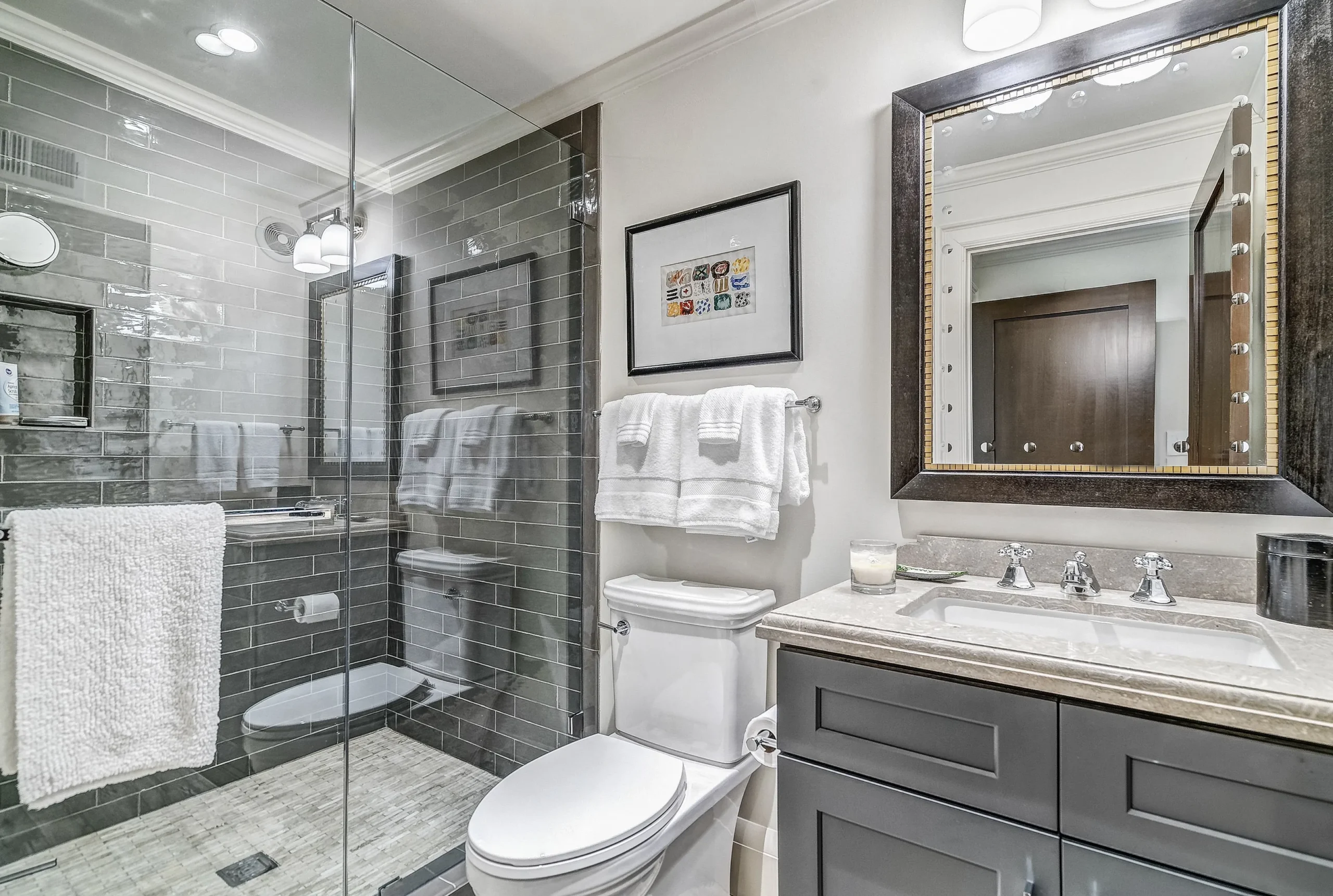 Bathroom Cabinet Painting and Renovation in North Atlanta Modern bathroom with dark grey painted vanity cabinets and glass shower in North Atlanta.