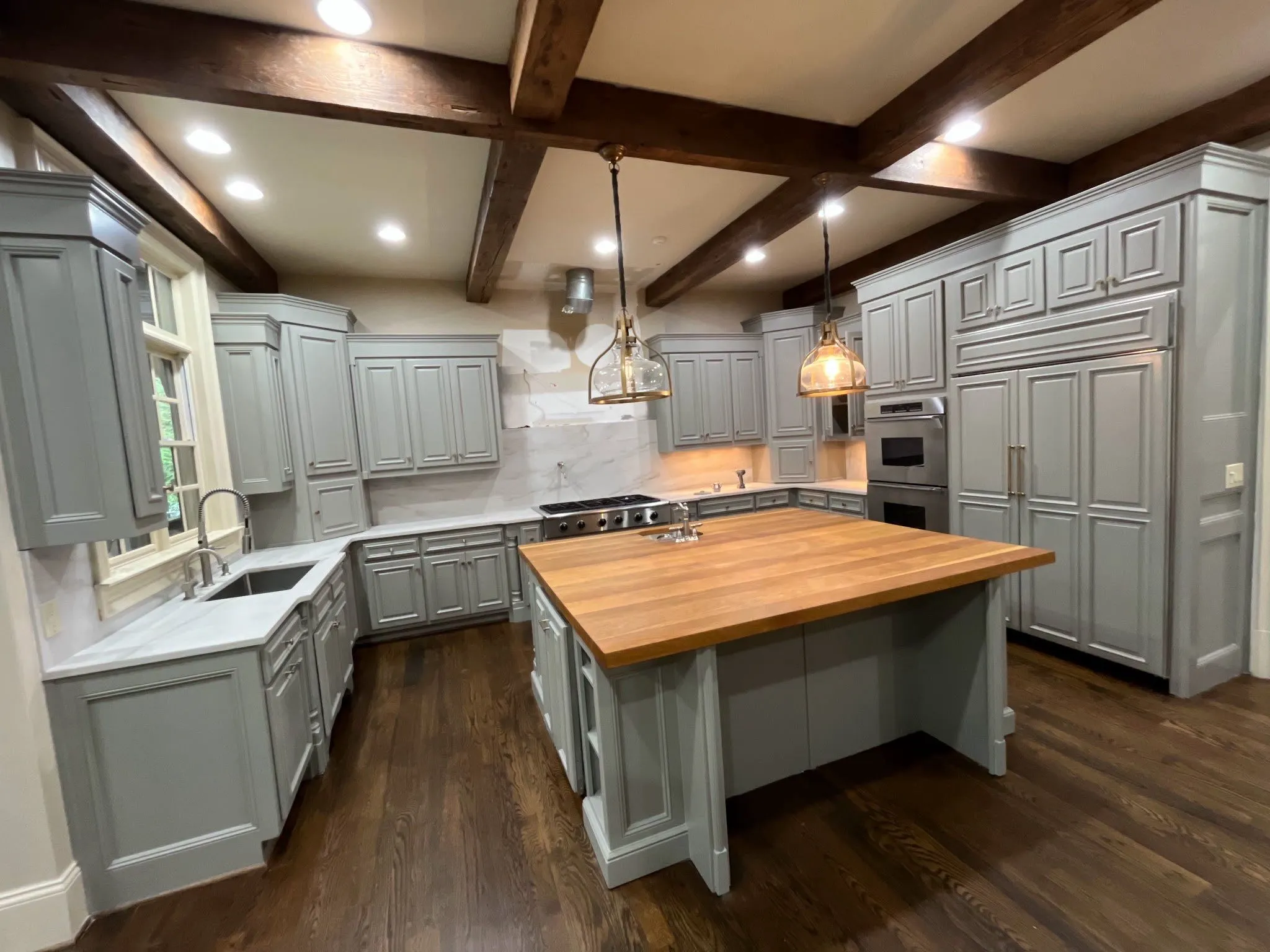 Kitchen Cabinet Painting and Wood Staining in North Atlanta Beautifully painted grey kitchen cabinets with a wood stained island countertop in North Atlanta.