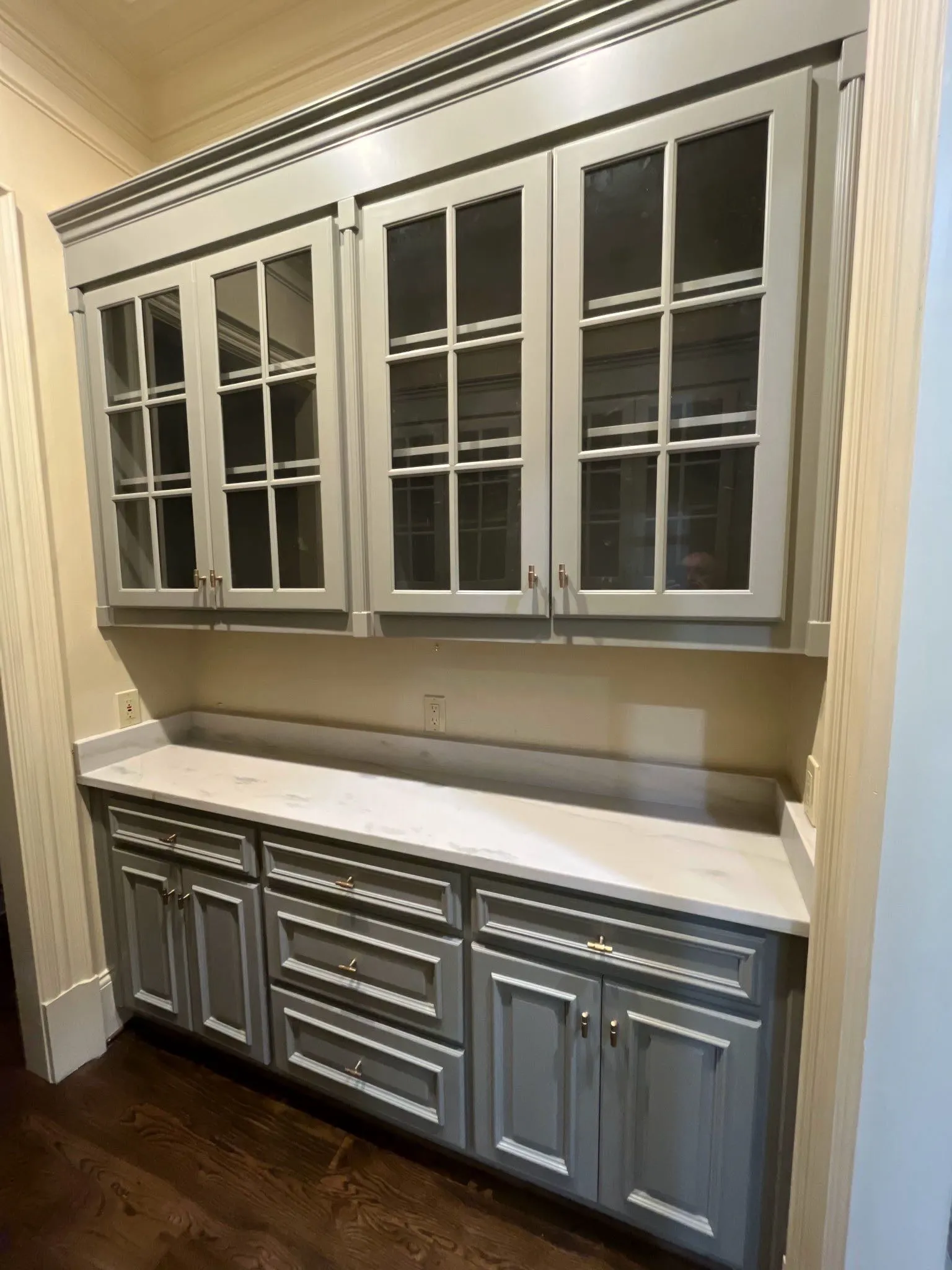 Custom Cabinet Painting and Built-ins in North Atlanta Custom painted grey cabinets with glass doors and white countertop in a North Atlanta home.