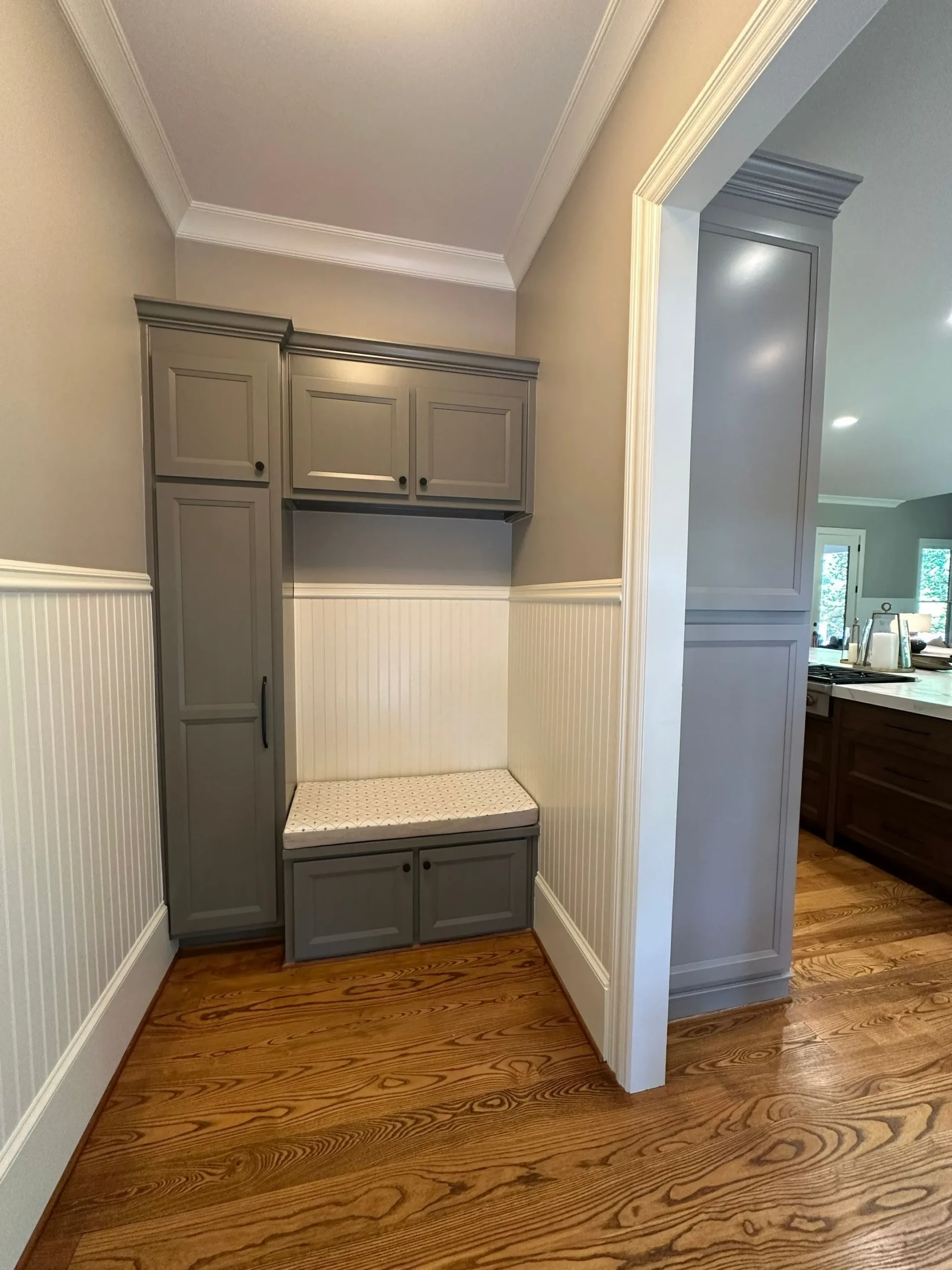 Mudroom Cabinet Painting and Storage Solutions North Atlanta Painted grey mudroom cabinets with white wainscoting and bench seating in North Atlanta.