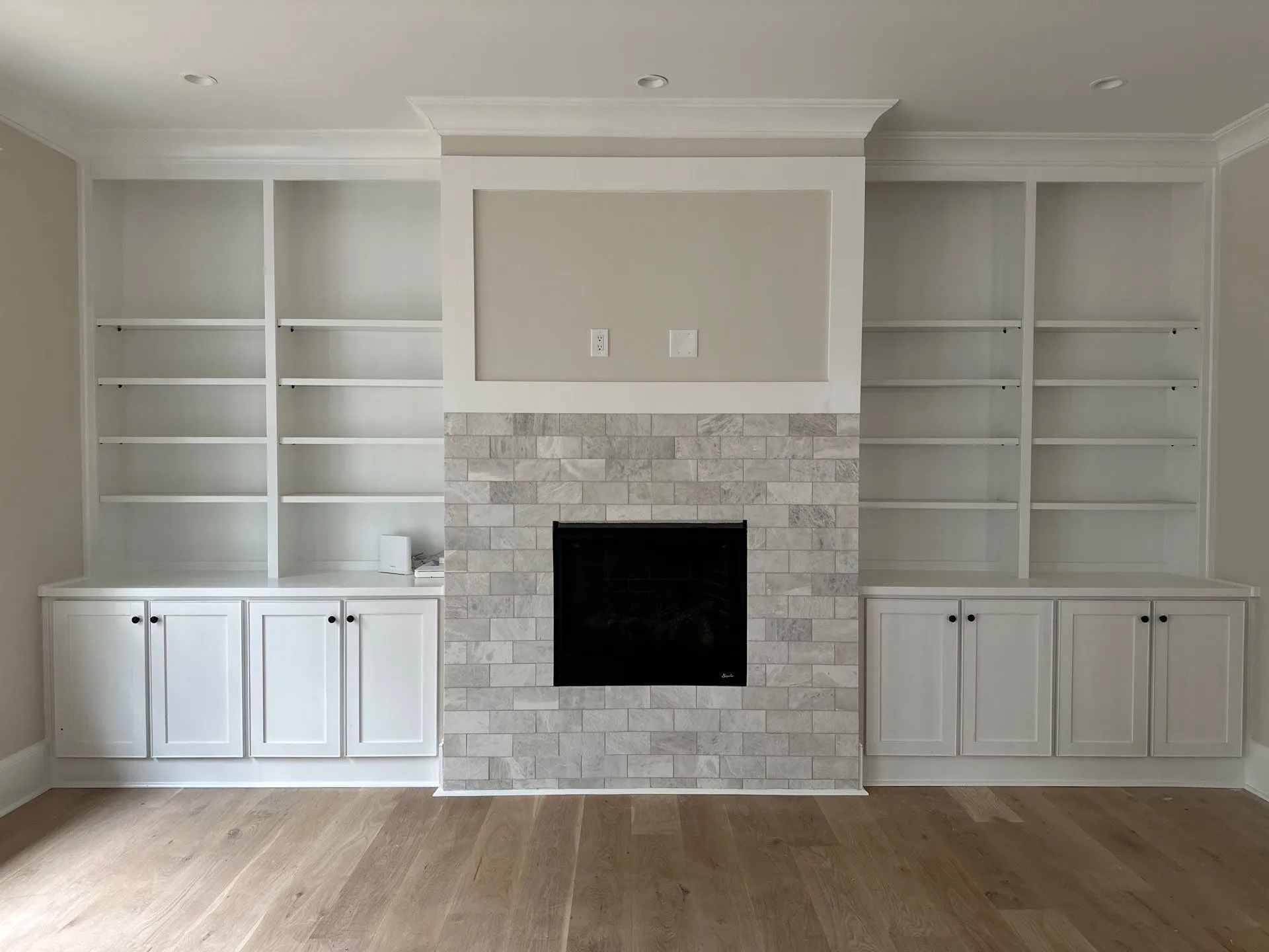 Built-in Cabinet Painting and Fireplace Accent in North Atlanta White painted built-in cabinets flanking a stone fireplace in a North Atlanta living room.