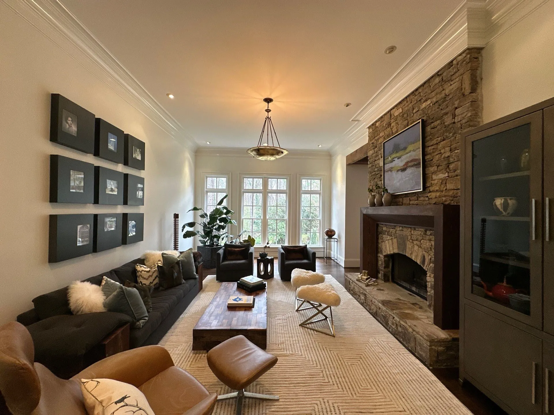 Living Room Interior Painting North Atlanta Elegant living room with light walls, a stone fireplace, and comfortable seating in North Atlanta.