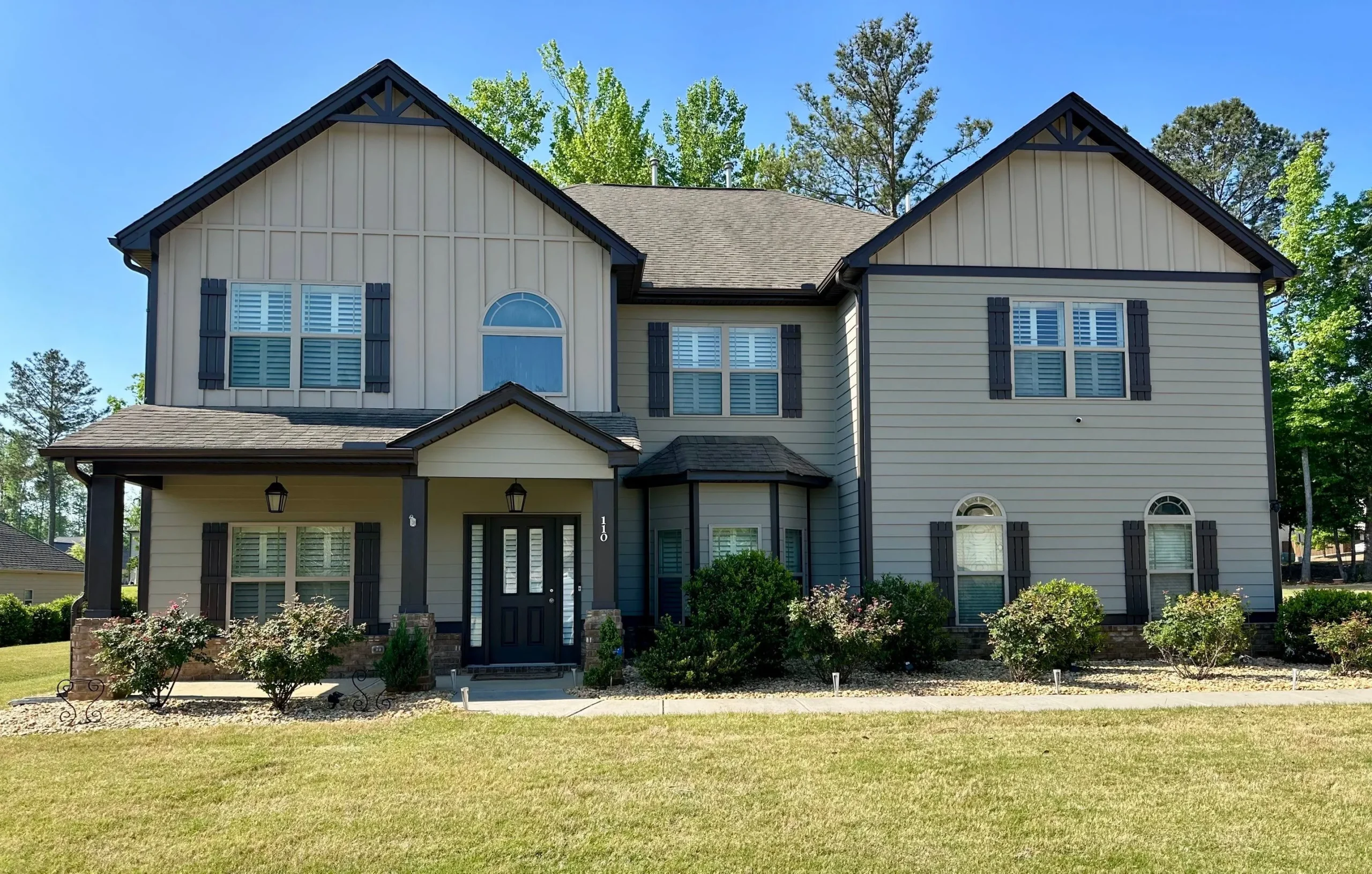 Exterior House Painting North Atlanta Two Story Home Front view of a two-story residential home with light siding and dark trim in North Atlanta.