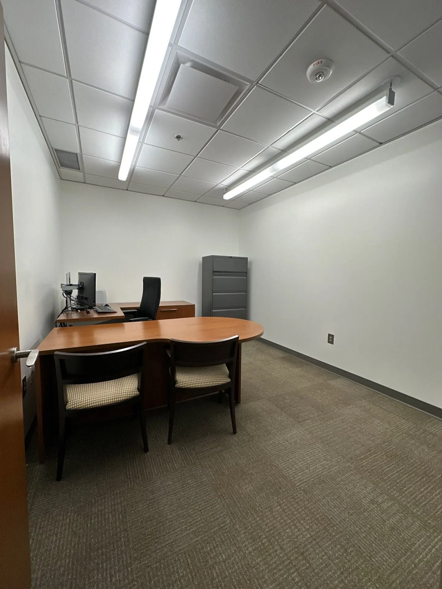Commercial Office Painting in North Atlanta Spacious commercial office with white walls, wooden desks, and chairs in North Atlanta.