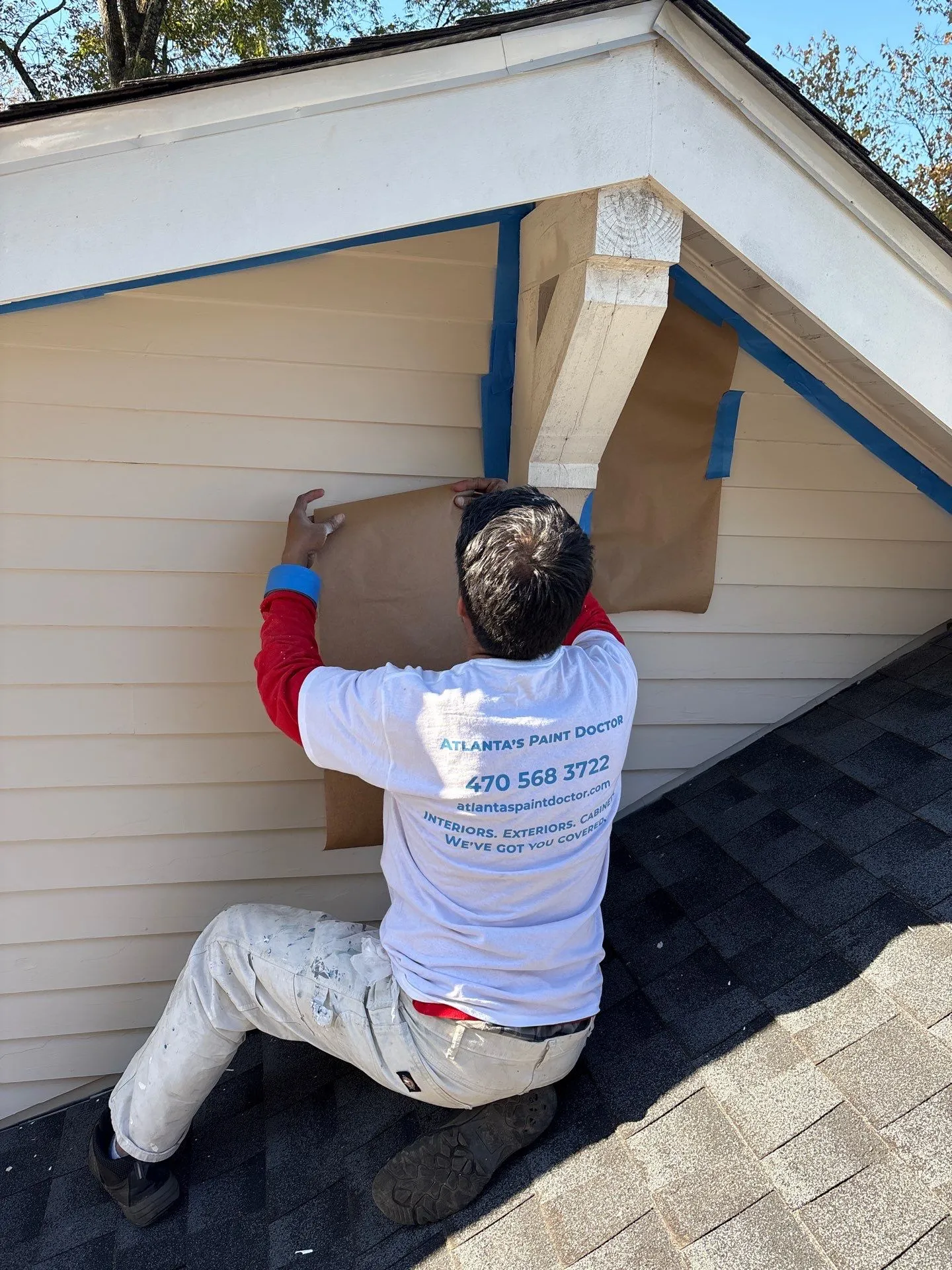 Exterior Siding Preparation North Atlanta Painter preparing exterior siding for painting with masking paper, offering exterior painting in North Atlanta.