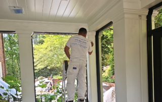 How Often Should You Repaint Your Home’s Exterior in Atlanta’s Climate? - Painter painting with a brush an exterior porch column