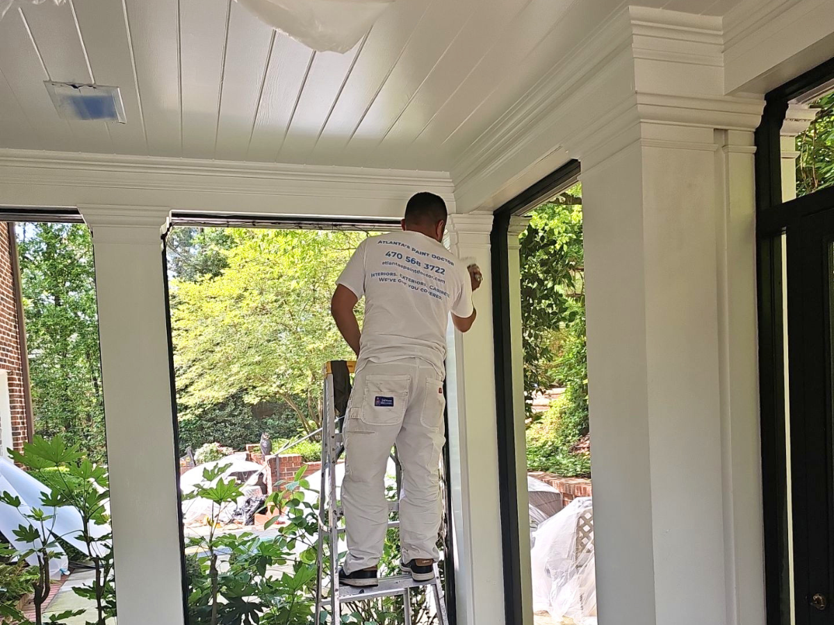 How Often Should You Repaint Your Home’s Exterior in Atlanta’s Climate? - Painter painting with a brush an exterior porch column