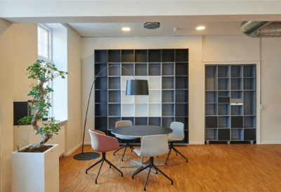 Modern Home Office Interior Painting Cream-painted residential home office with built-in navy blue shelving, wood flooring, and contemporary furniture.