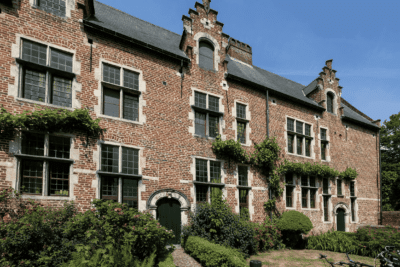 Brick Residential Home Exterior Red brick residential home exterior with green ivy climbing facade, multi-pane windows, and ornate roofline in Buckhead, GA.