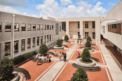 Terracotta Commercial Courtyard Painting Terracotta and cream painted commercial courtyard with modern landscaping, seating areas, and multi-story building facade.