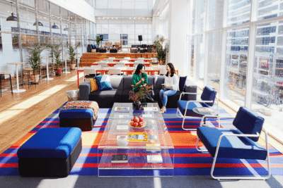 Orange And Blue Commercial Interior Bright orange and blue painted commercial office lounge with navy seating, colorful geometric floor pattern, and