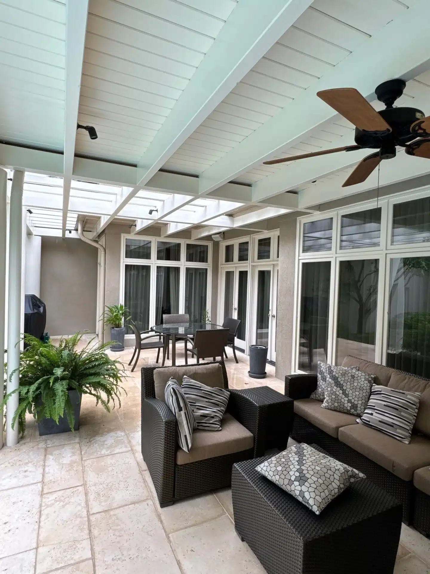 Mint Green Painted Patio Ceiling Mint green painted patio ceiling with white shiplap boards, ceiling fan, and glass doors overlooking seating area.